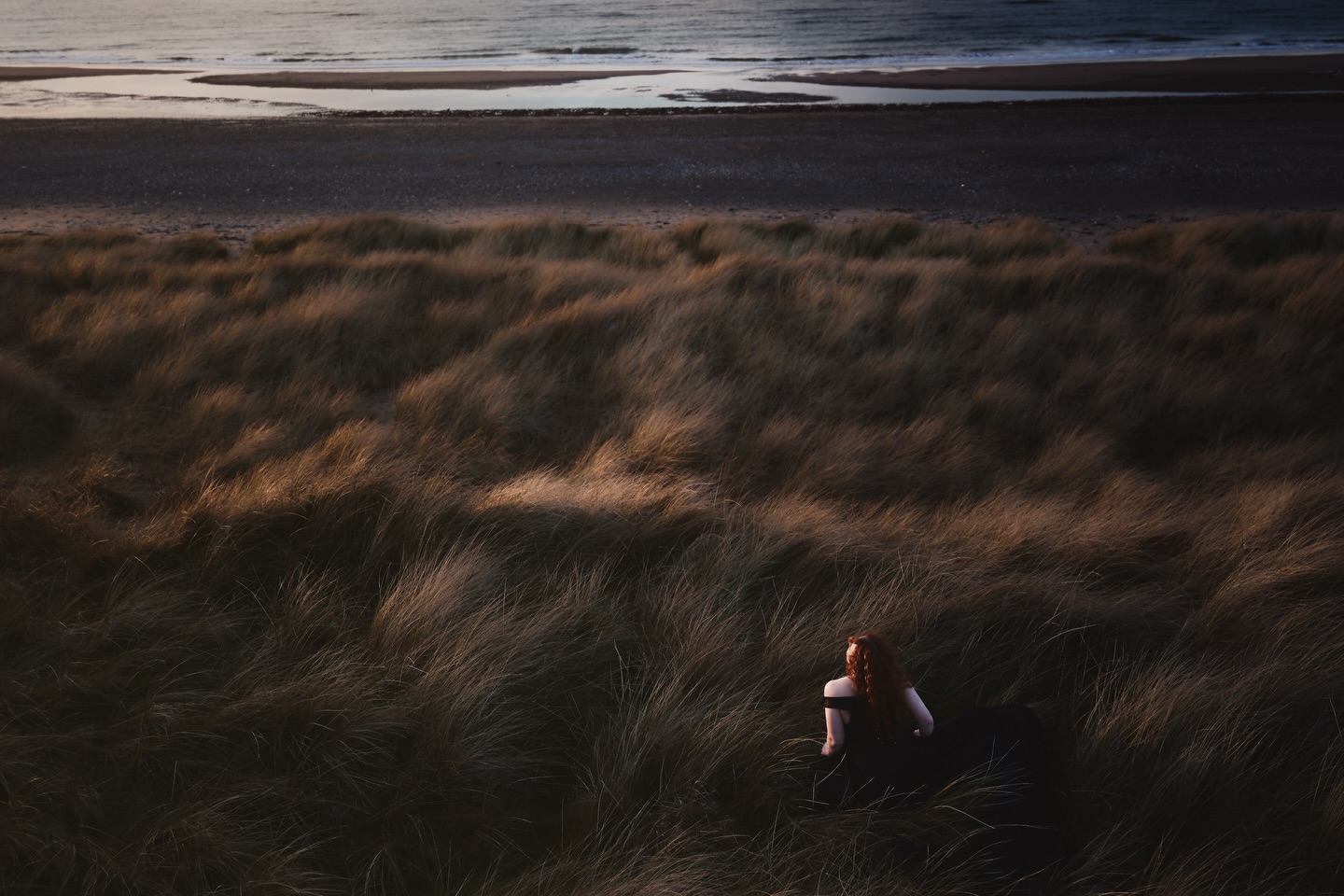 Figure in dunes — sea visible in the distance, Isle of Man