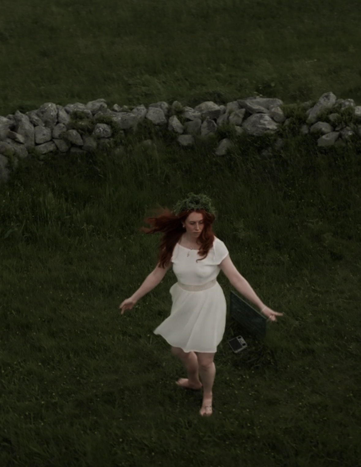 Dancing barefoot inside the stone circle, flower crown, white dress